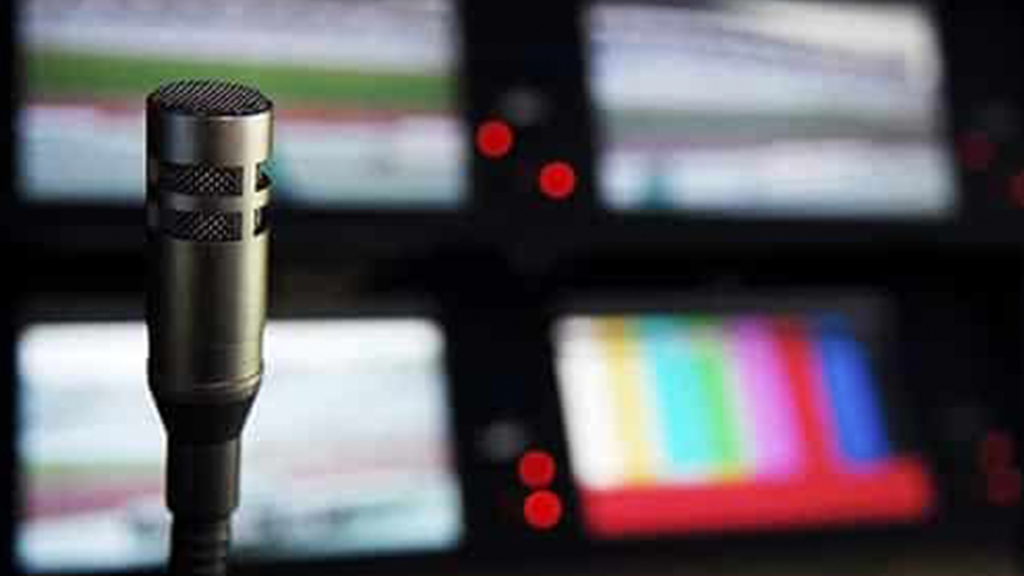 A microphone with blurred screens in the background.