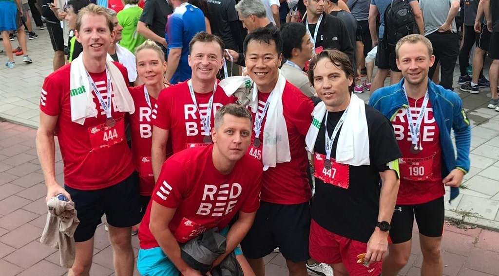 A group of Red Bee employees in running gear posing for a photo.