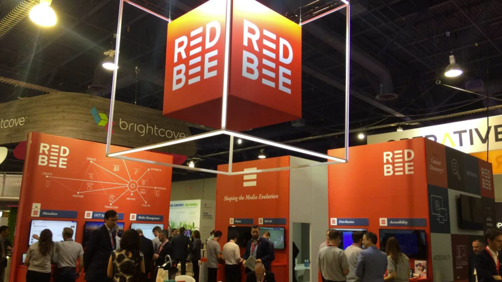 Red Bee logos and stands at an event.