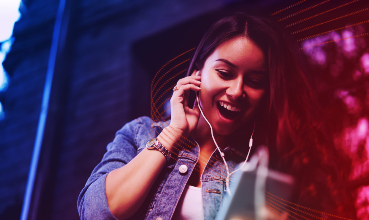 A joyful woman listening to some earphones.