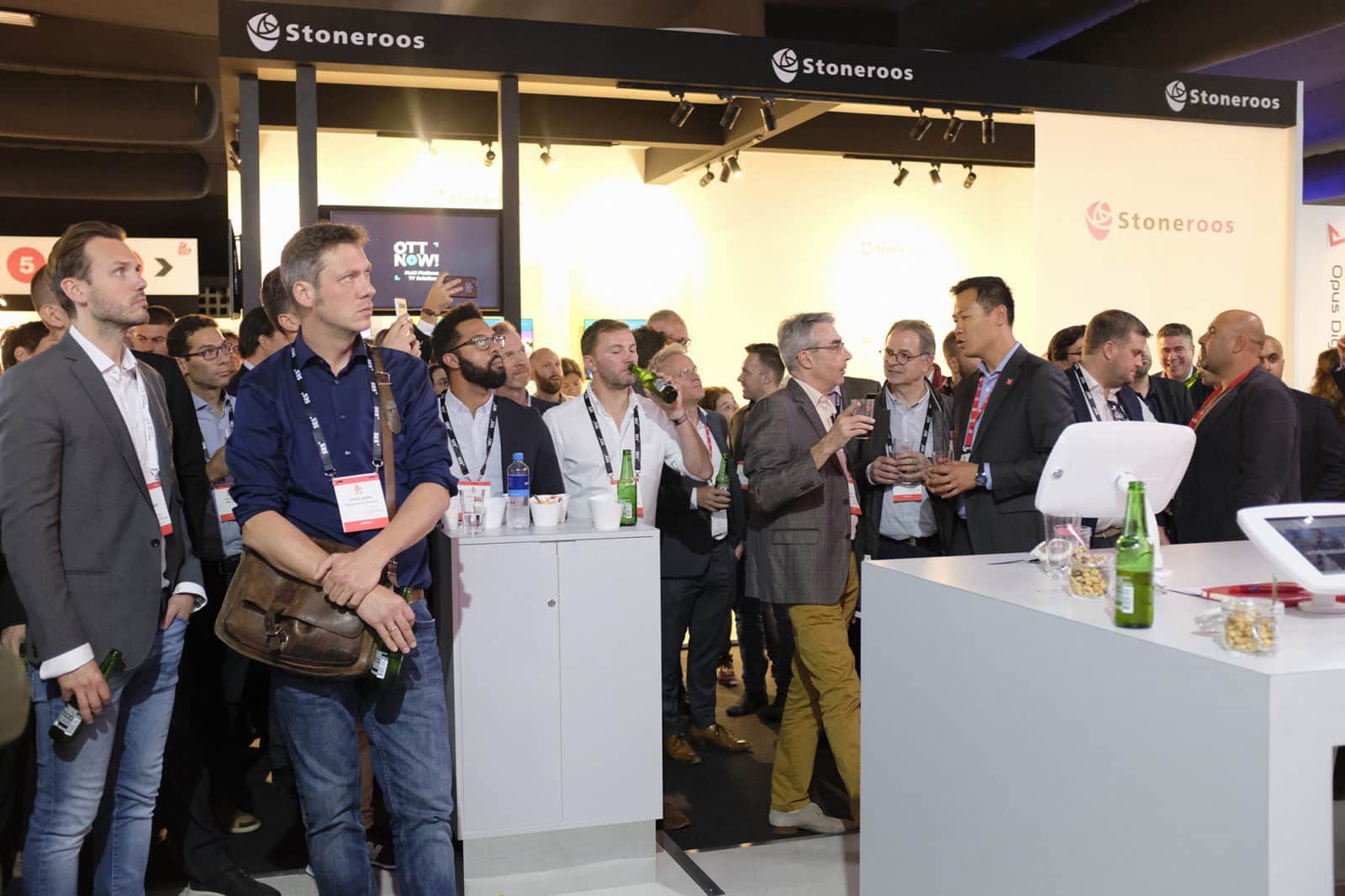 A group of people gathered near a table with tablet devices attached to it.