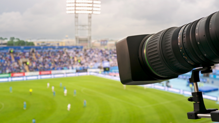 A telephoto camera lens pointing at a football match.