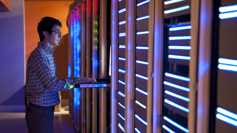 A man standing in a computer server room.