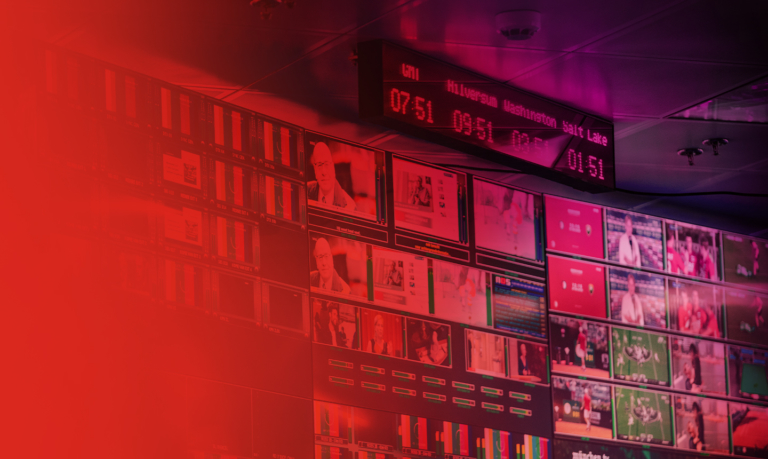A wall of screens with a red hue.