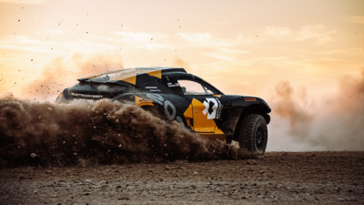 A rally car kicking up dirt.