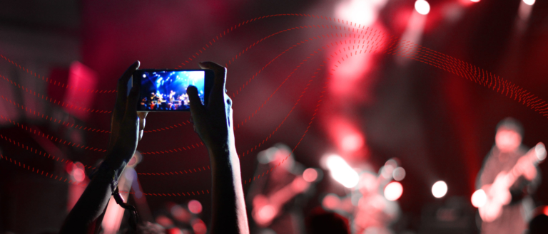 A person photographing a gig on their phone.
