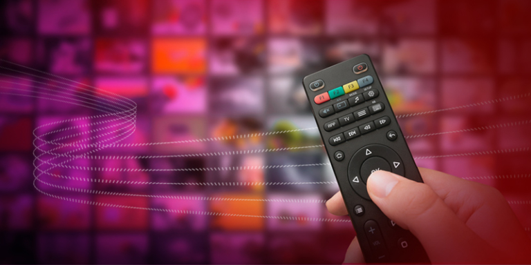 A hand holding a television remote control.