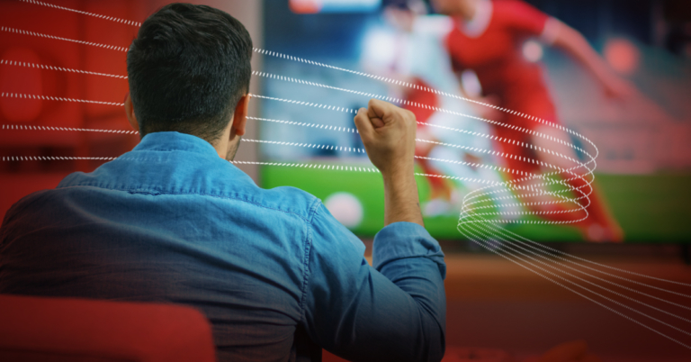 A man pumping his fist as he watches football.