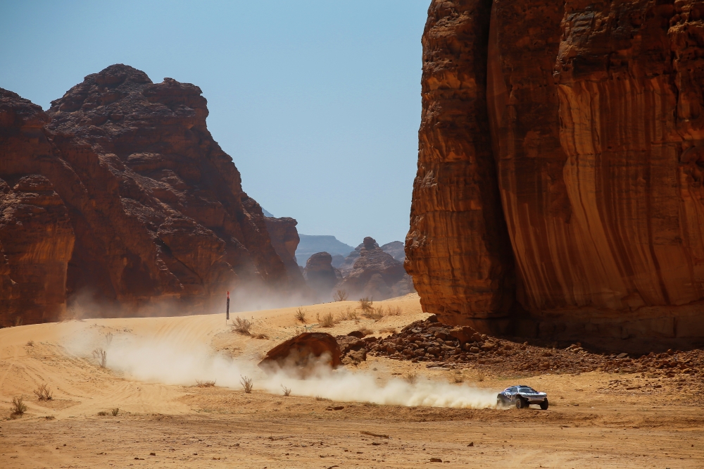 Sara Price (USA)/Kyle Leduc (USA), Segi TV Chip Ganassi Racing A car racing through a desert landscape beside towering rocks.