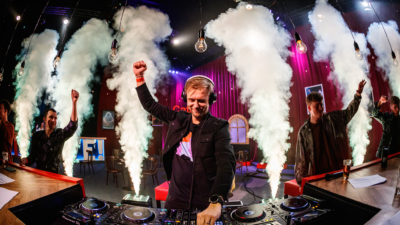 A DJ with clouds of smoke erupting behind him.