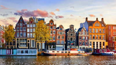 A row of tall, narrow, crooked houses overlooking a canal.