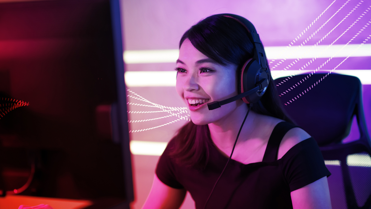 Six pink-and-white, dotted lines passing behind a smiling woman wearing a headset in front of a computer.