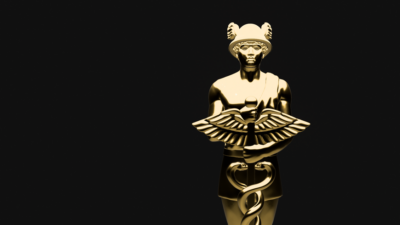 A gold-coloured Hermes figurine against a black background.