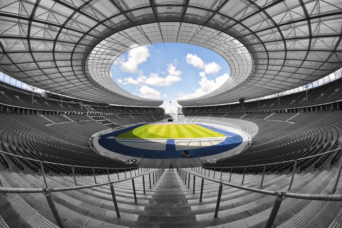 "The Paralympic Games have also provided an excellent moment in time to double-check that our guidelines on describing disability are just as they should be." A wide angle shot of an empty stadium. The stadium is in black and white but the pitch is bright green, and the running track and sky are blue.