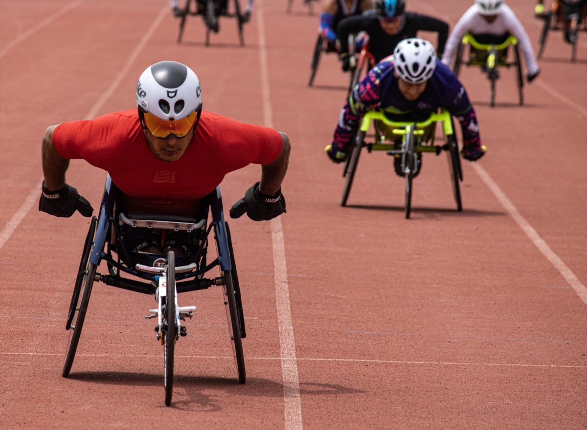 Wheelchair racers powering along a track Wheelchair racers powering along a track.